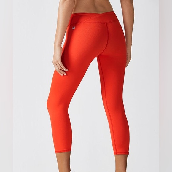 Fabletics Midrise Capris in orange with crossover waistband and hidden pocket - Picture 2 of 8
